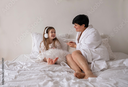 Family using phone in bed