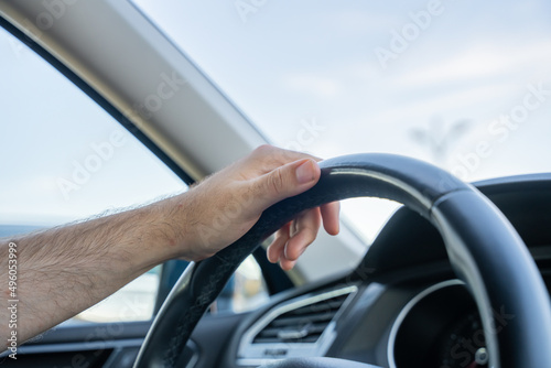 Mano de hombre sujetando el volante.