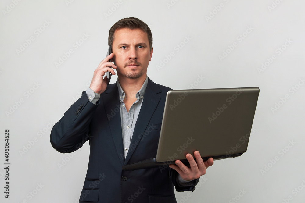 Young businessman using laptop and phone on white background Young businessman using laptop and phone on white background