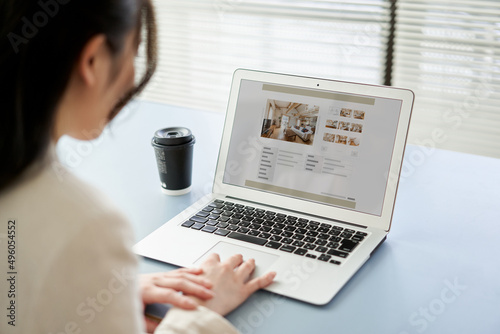 パソコンで不動産サイトを見るアジア人女性
