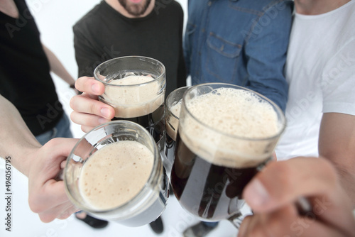 close up.mugs of beer in the hands of a group of men