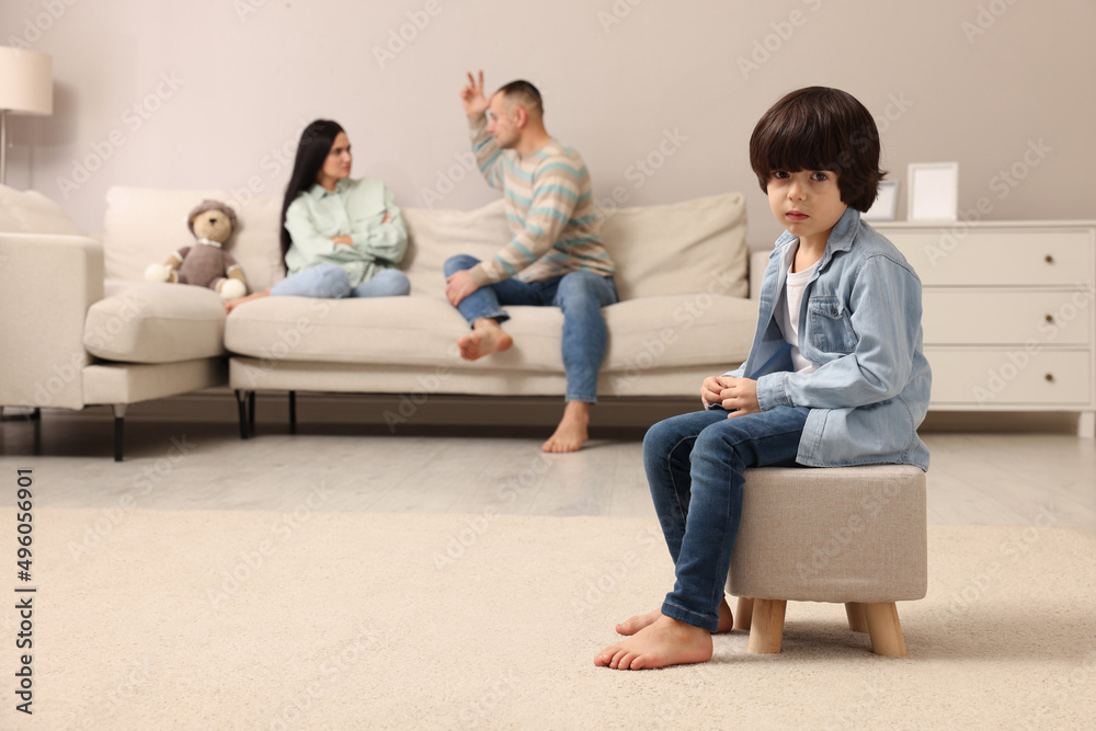 Couple arguing at home, focus on their upset child Couple arguing at home, focus on their upset child