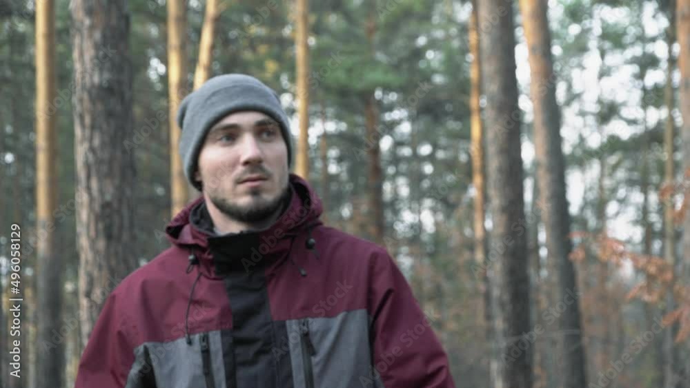 A man in a hat walks through the woods. Portrait of a young male traveler. Forester walking through the forest A man in a hat walks through the woods. Portrait of a young male traveler. Forester walking through the forest