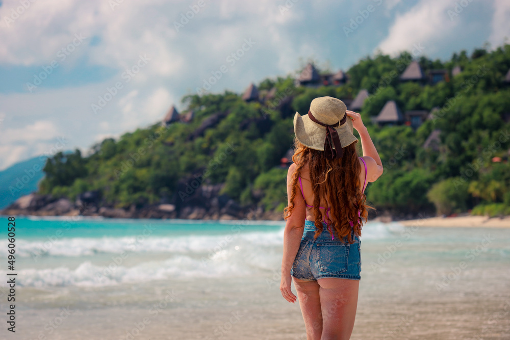 A girl in a hat on a beautiful paradise beach