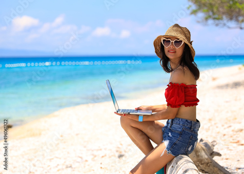 Happy lifestyle with work vacation with young asian woman freelancer sitng as working on the beach-Summer vacation concept © SASITHORN