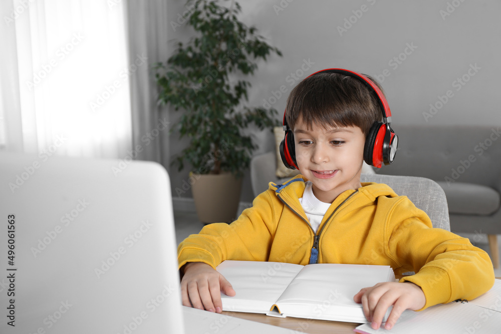Cute little boy with modern laptop studying online at home. E-learning Cute little boy with modern laptop studying online at home. E-learning