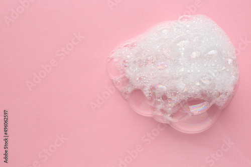 Drop of bath foam on pink background, top view. Space for text