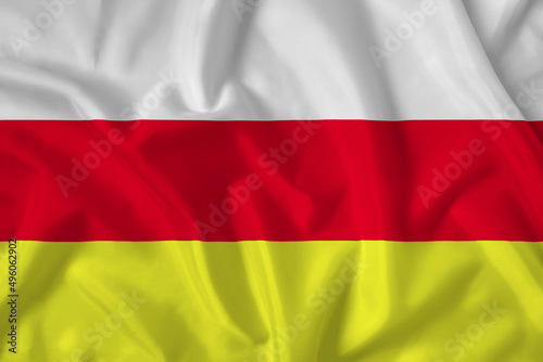 North Osetia flag with fabric texture. Close up shot, background