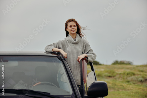 pretty woman with red hair in a sweater near the car nature unaltered