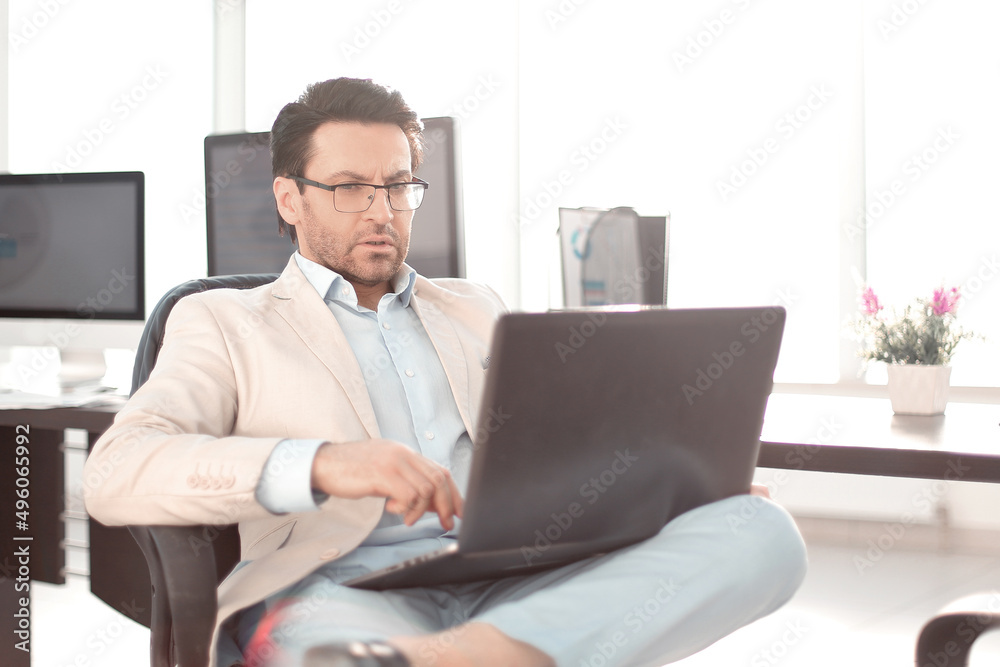 businessman using a laptop sitting at his Desk businessman using a laptop sitting at his Desk