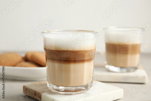 Glasses with delicious latte macchiato on white table