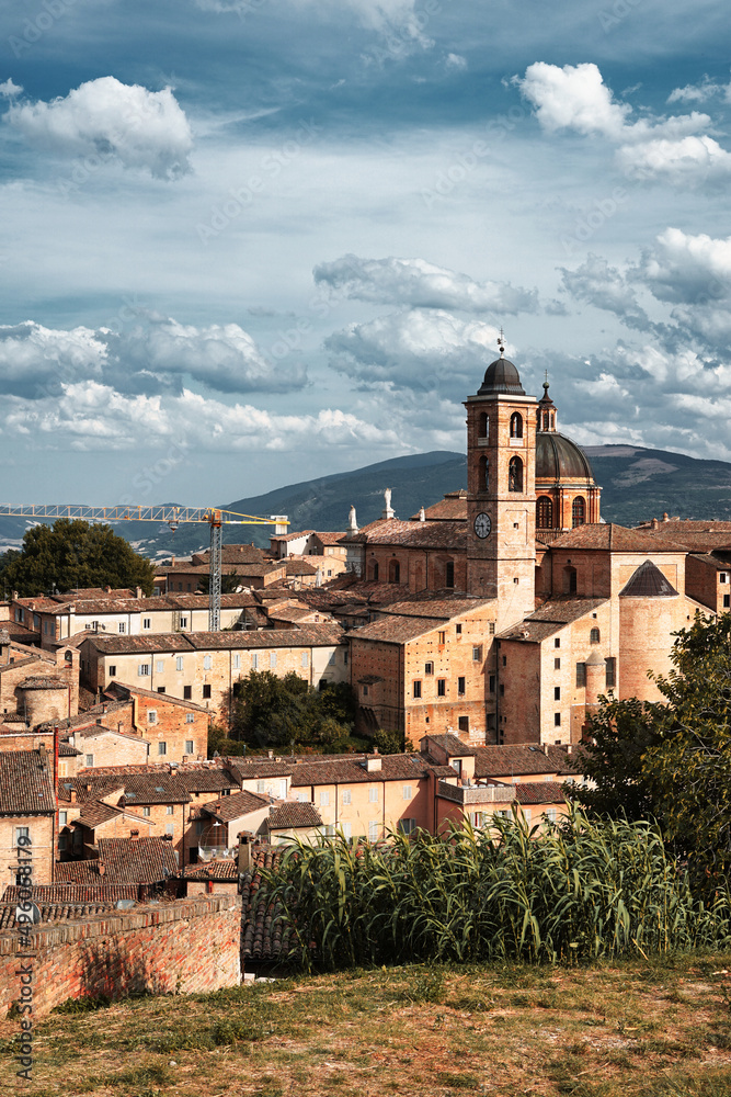 Panoramic view of the city of Urbino, Italy. Ancient italian renaissance city, Unesco world heritage site. Houses, palaces, cathedrals and towers of the Doge's Palace under a cloudy sky.