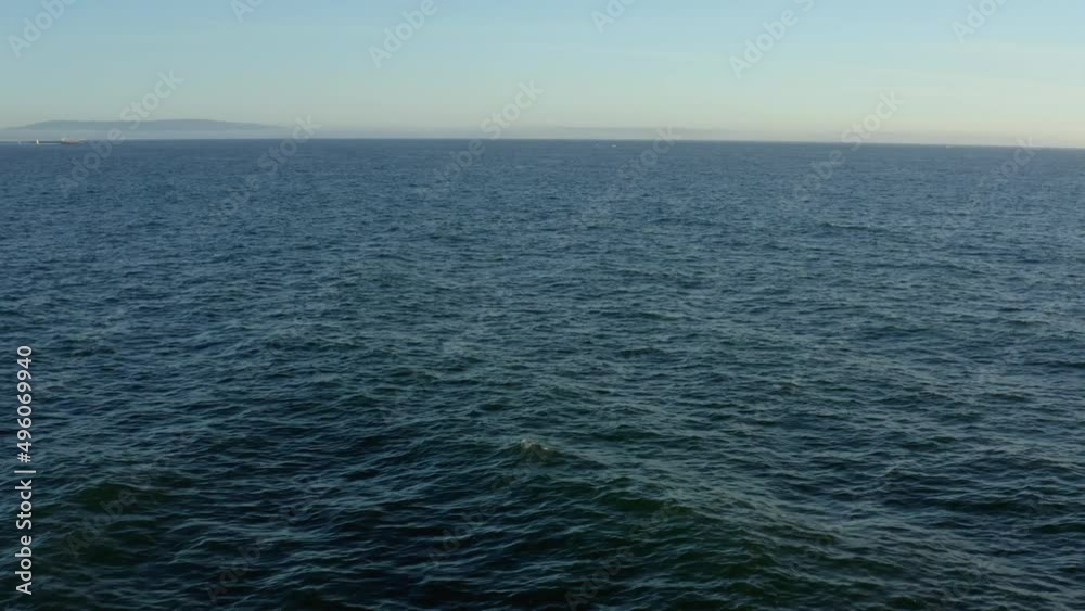 Surfer riding and turning with spray on blue ocean wave Surfer riding and turning with spray on blue ocean wave