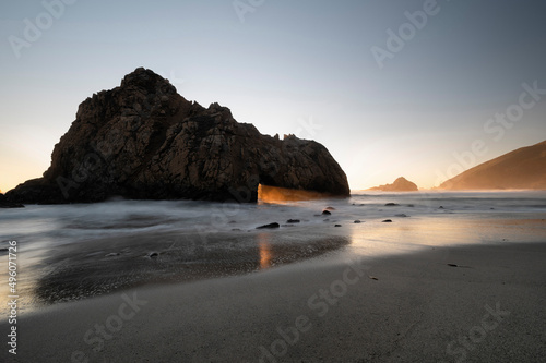 Keyhole rock on Pfeiffer Beach with sun beam shining through photo