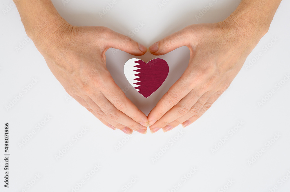 Fototapeta premium The national flag of Qatar in female hands.