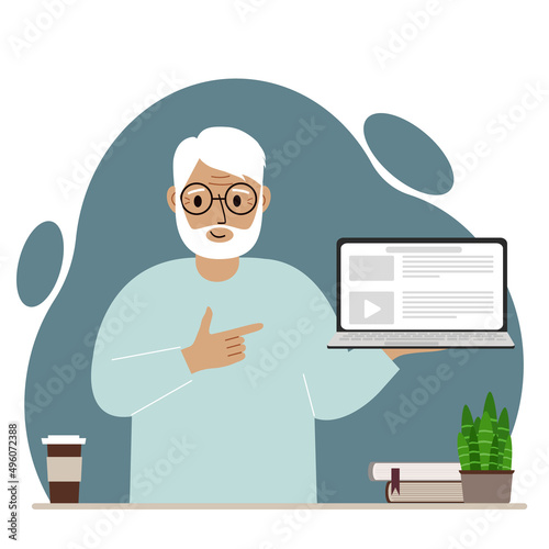 Happy grandfather holding a laptop computer with one hand and pointing at it with the other. Laptop computer technology concept.