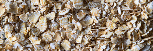 Top view of oat flakes for texture background or design.Banner woth space for text