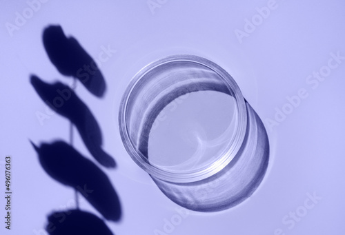 Empty laboratory glass petri for serum, oil, beauty products on violet background. Natural medicine, cosmetic research, bio science. Concept of skincare and analysis. Dermatology. Flat lay, top view