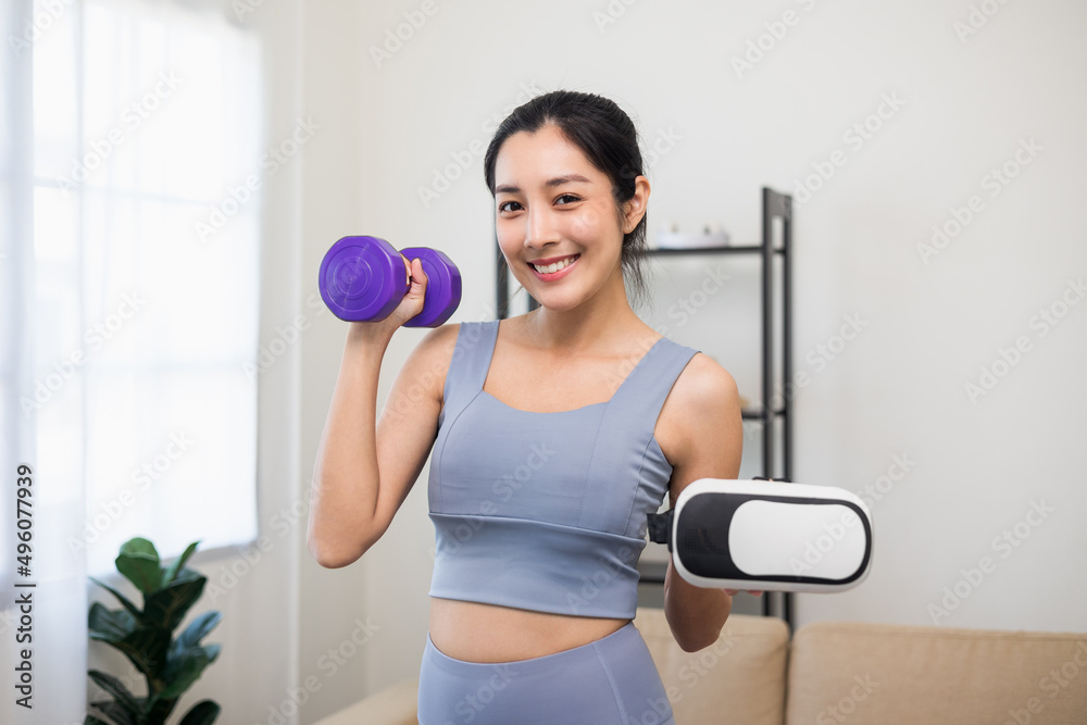 Training holding dumbbell and virtual glasses. Young asian sport woman wearing sportswear workout with virtual simulated world. Into the future digital cyber universe. Future technology Training holding dumbbell and virtual glasses. Young asian sport woman wearing sportswear workout with virtual simulated world. Into the future digital cyber universe. Future technology