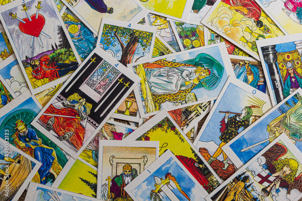 Background with pile of the tarot cards, the major arcana deck. Fortune telling seance or black magic ritual. Scary still life with occult and esoteric symbols. Halloween or divination rite Background with pile of the tarot cards, the major arcana deck. Fortune telling seance or black magic ritual. Scary still life with occult and esoteric symbols. Halloween or divination rite