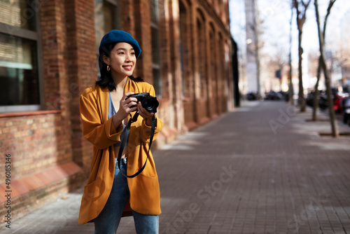 Beautiful Chinese woman with camera. Happy smiling woman taking photos of beautiful location...