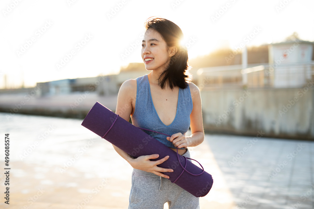 Beautiful young woman training outside. Fit woman doing stretching exercise..