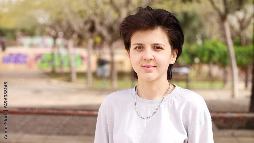 Non-binary teenager looking at camera and smiling Non-binary teenager looking at camera and smiling