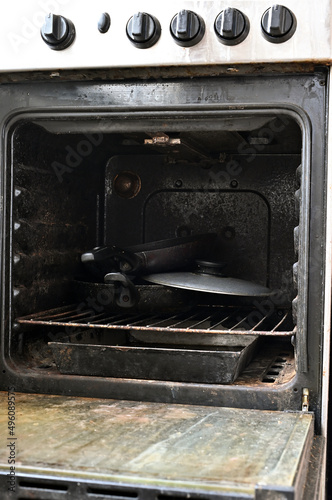 old rusty gas stove in the apartment, open stove door, gas stove from the inside, front view