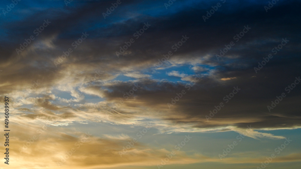 Obraz premium Ciel jaunâtre pendant le coucher du soleil. On observe d'esthétiques reflets sous des nuages voilés de haute altitude