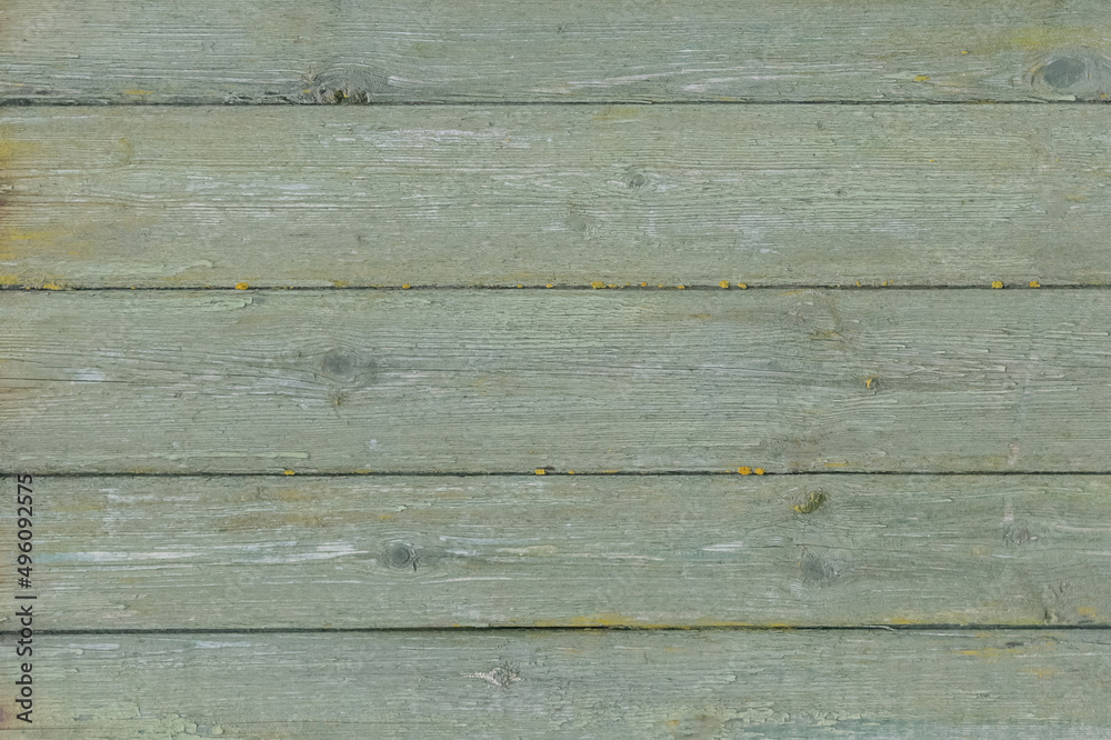 Old wooden worn fence boards weathered texture in peeling green paint dirty obsolete background Old wooden worn fence boards weathered texture in peeling green paint dirty obsolete background