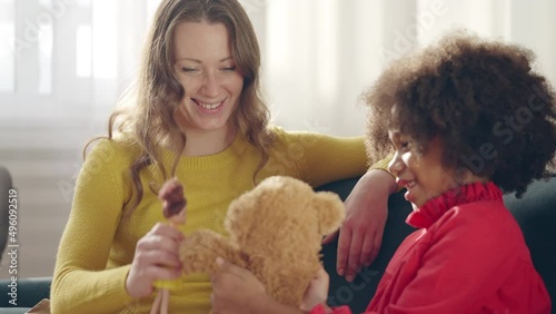Happy mother playing games with her daughter, multiethnic family, adoption