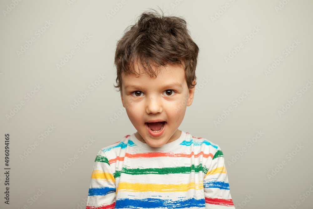 The child laughs. Portrait of a six-year-old Caucasian boy on a yellow background The child laughs. Portrait of a six-year-old Caucasian boy on a yellow background