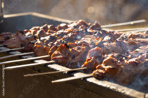 spieße auf Stäbchen werden auf Holzkohle gegrillt, Stöcke liegen senkrecht zur Frühlingszeit.