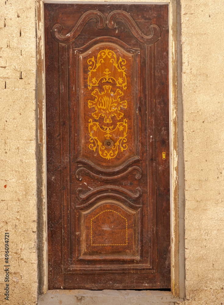 Old single rusted wooden door, wood door with beige color wall, Hurghada, Egypt