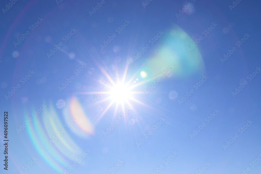 Rainbow arcs glare from the bright sun on the blue sky. Beautiful background to illustrate celestial phenomena, aura, high vibrations, the universe Rainbow arcs glare from the bright sun on the blue sky. Beautiful background to illustrate celestial phenomena, aura, high vibrations, the universe