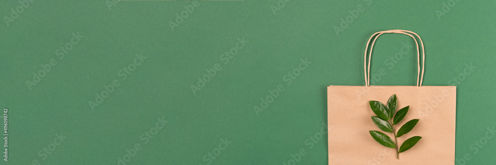 Recycled kraft paper bag with green leaves on green background ...