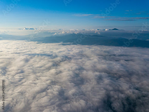 High flight above the clouds in the mountains. Aerial drone view.