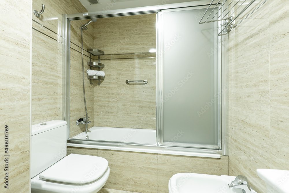 Obraz premium Bathroom with shower cabin with chrome screen, marble tiling and chrome accessories