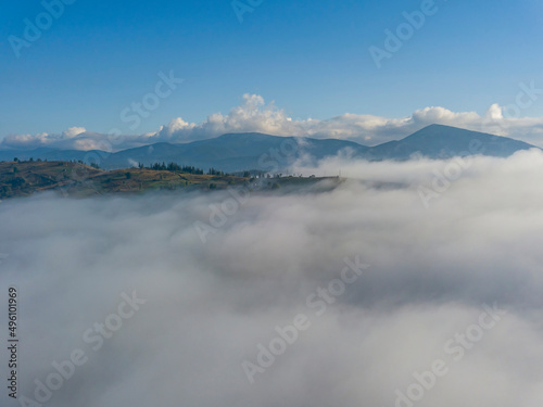 High flight above the clouds in the mountains. Aerial drone view.