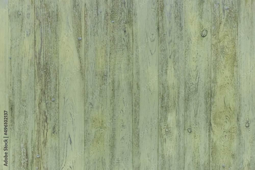 Old wooden worn fence boards weathered texture in peeling green paint dirty obsolete background
