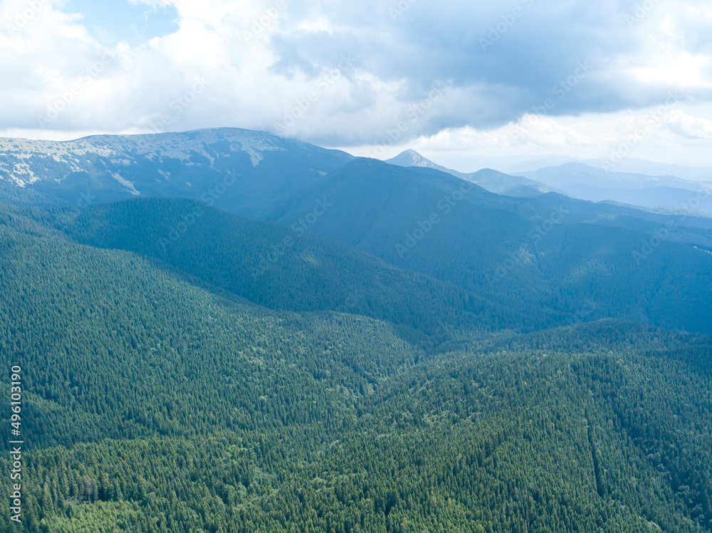 Green mountains of Ukrainian Carpathians in summer. Sunny day, rare clouds. Aerial drone view.