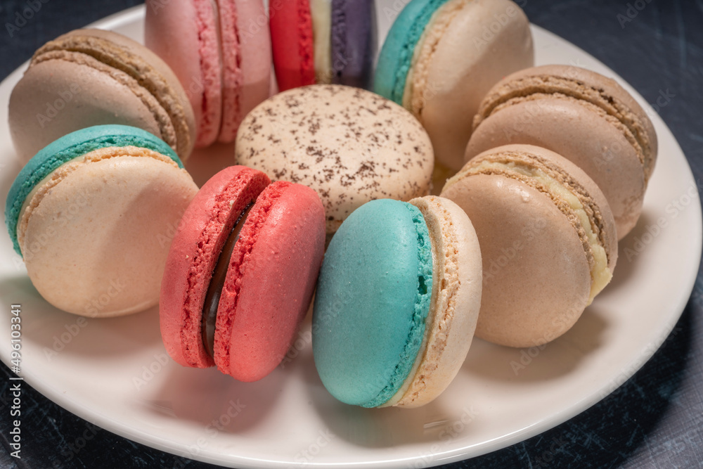 Colorful macarons in white plate on wooden table, Sweet makaron from almond flour and cream. Colorful macarons in white plate on wooden table, Sweet makaron from almond flour and cream.