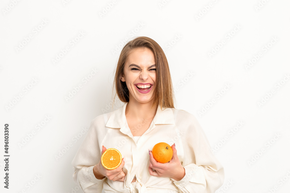 Young Caucasian smiling woman holding slices orange over isolated white background, breast health concept Young Caucasian smiling woman holding slices orange over isolated white background, breast health concept