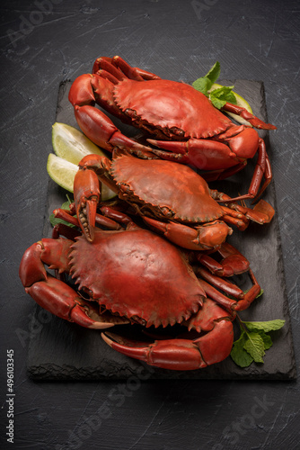 Steamed Red Crab with butter and lemon, Boiled Serrated mud crab on black plate on black background, photo