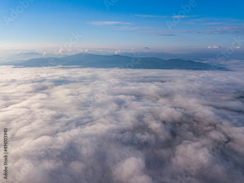 High flight above the clouds in the mountains. Aerial drone view. © Sergey