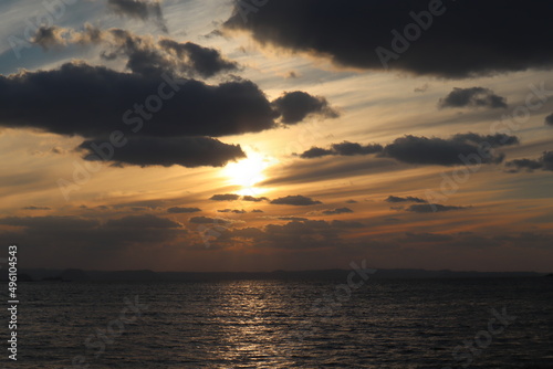 雲の合間から海に沈みゆく夕日 © 聡 藤崎