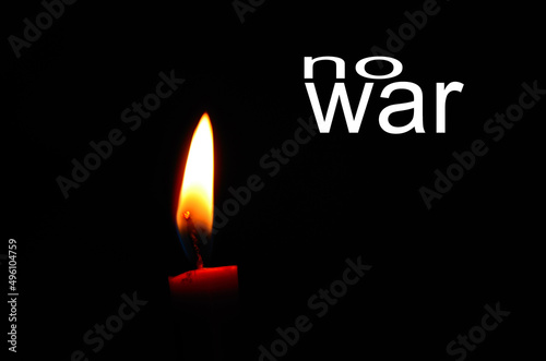 no war detail view from a red burning candle in the black