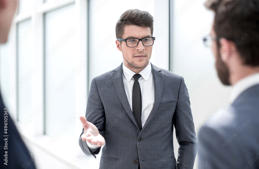 boss talking to employees standing in the office boss talking to employees standing in the office
