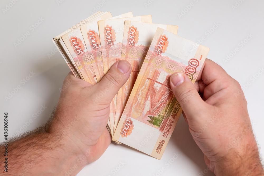 Hand with Russian rubles on a white background, bills five thousand rubles, money fan in hand