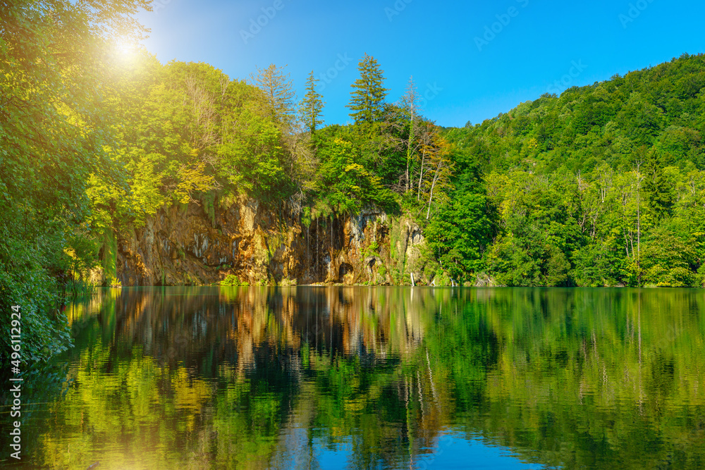 sunshine by the Galovac Lake with small waterfall in the Plitvice Lakes National Park of Croatia in Lika region. UNESCO World Heritage site.